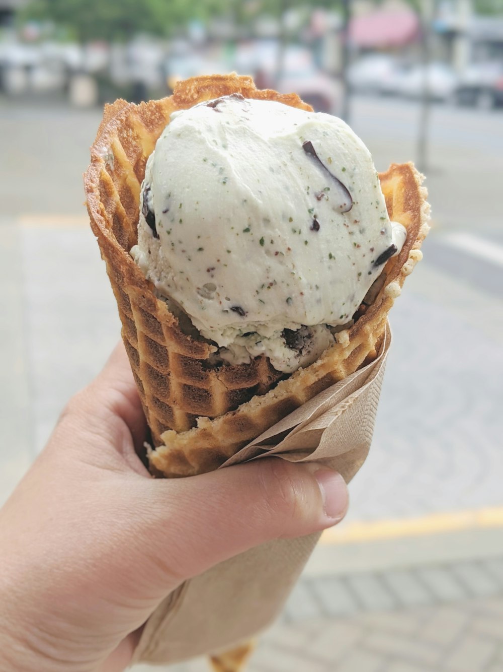 person holding ice cream cone with white ice cream