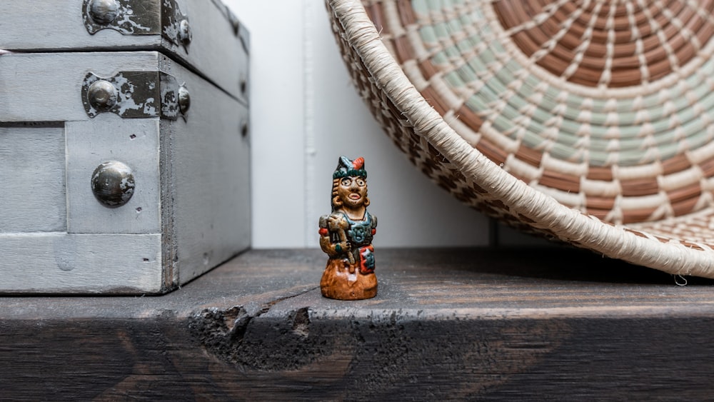 brown and black cat figurine beside brown wicker basket