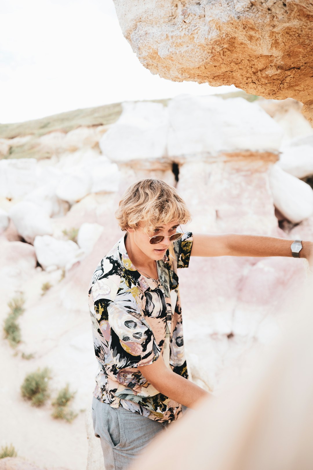 woman in black and white floral shirt standing and smiling