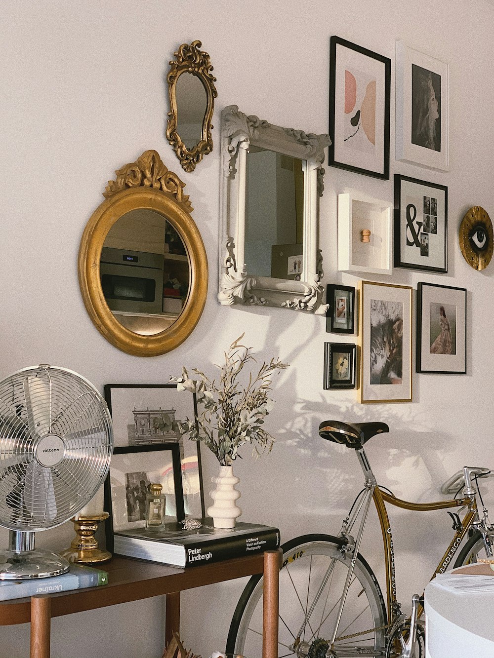 blue and black bicycle beside white stand fan