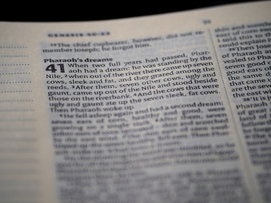 A close-up view of an open Bible, focusing on a section that includes the story of Pharaoh's dreams. The text is printed in two columns with a chapter heading in bold. The page appears to be slightly angled, with the text reading 'Pharaoh's dreams' and detailing a biblical passage.