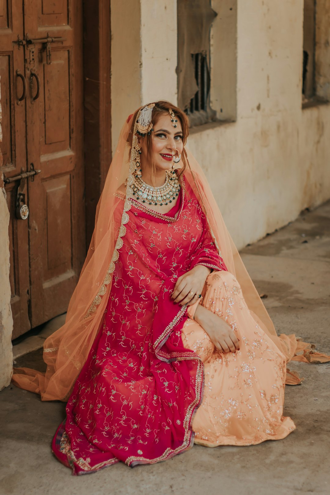 woman in pink dress sitting on brown wooden bench