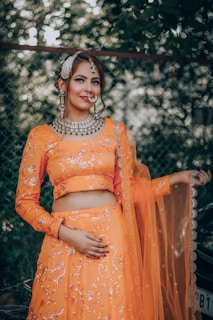 woman in orange long sleeve dress sitting on brown wooden armchair
