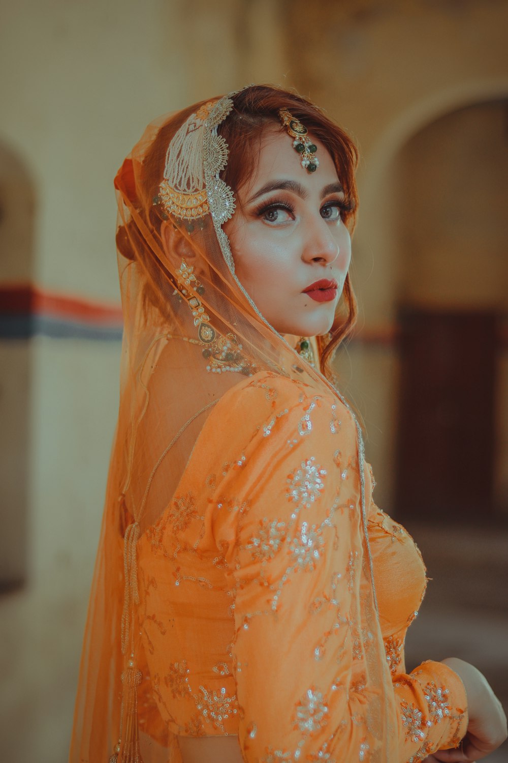 Mujer con vestido naranja con tocado floral blanco