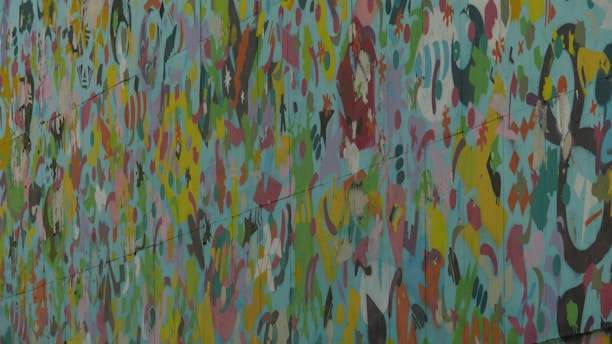 A vibrant mural depicting a peace symbol surrounded by colorful flowers and abstract shapes.