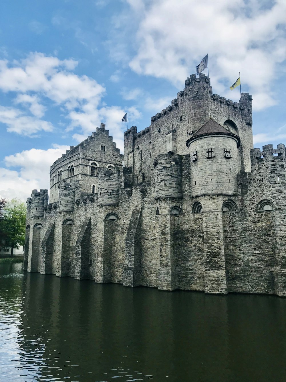 gray concrete castle near body of water during daytime