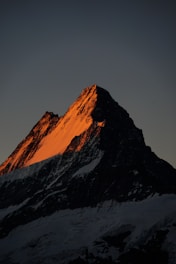 brown rocky mountain under gray sky