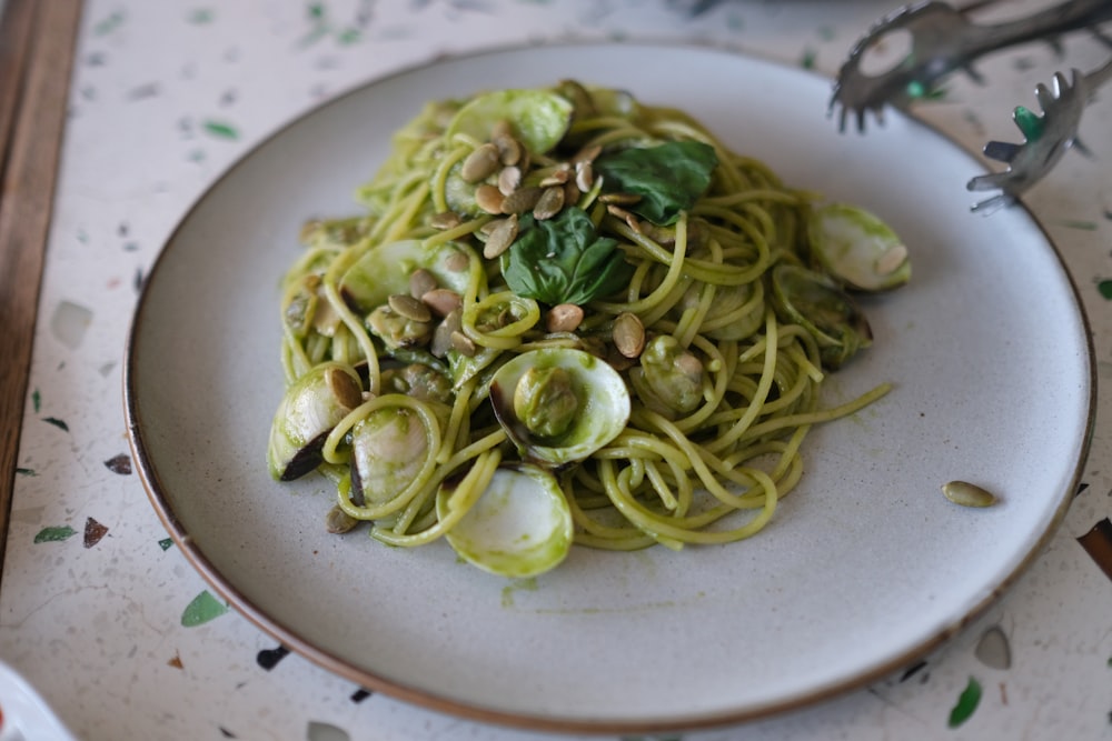 green and white pasta on white ceramic plate