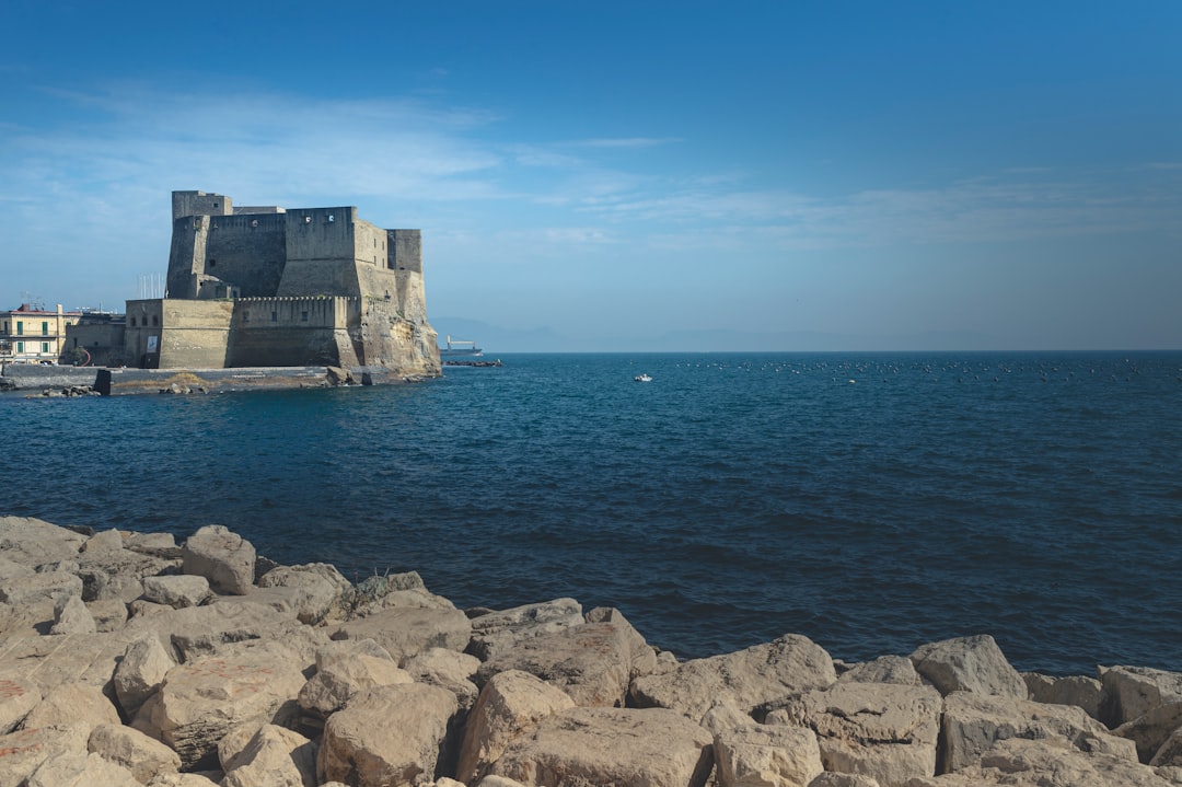 gray rock formation on sea under blue sky during daytime