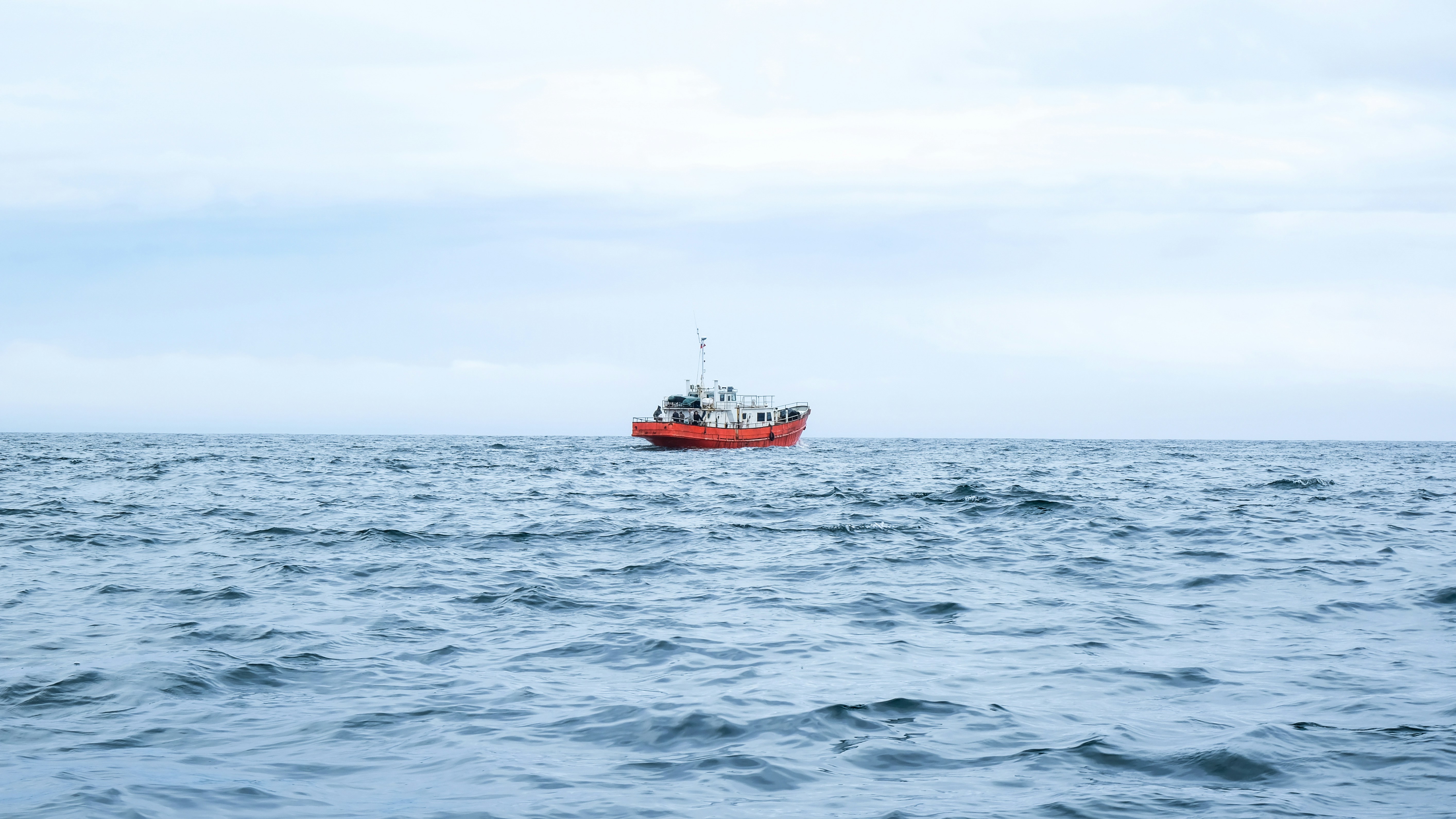 red and white boat on sea during daytime