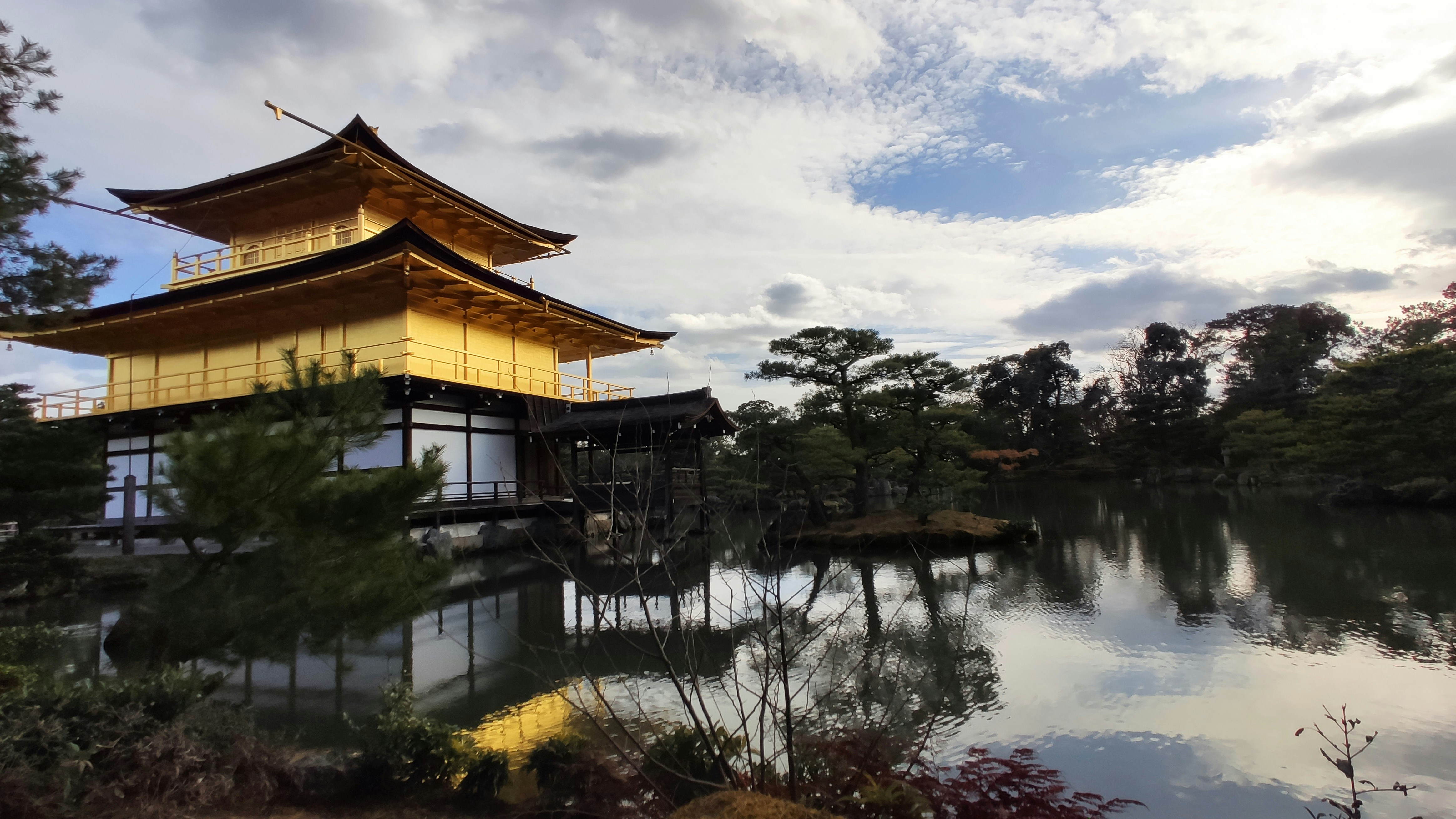 昼間の曇り空の下で湖の近くの茶色と白の家
