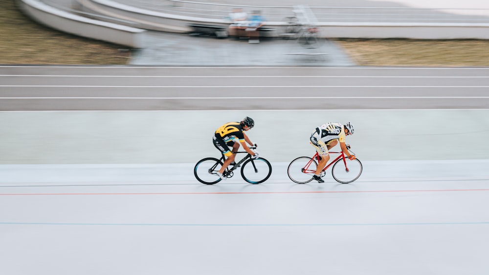 man in orange and black jacket riding on bicycle