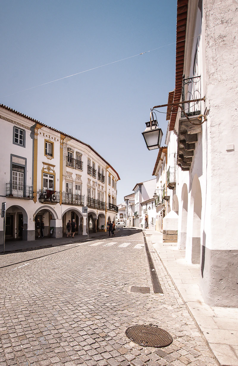 A quiet street of white and ochre arcaded houses in Évora