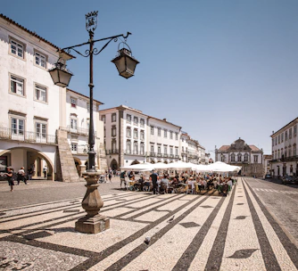 A cozy Spanish plaza bathed in warm sunlight with locals enjoying coffee.
