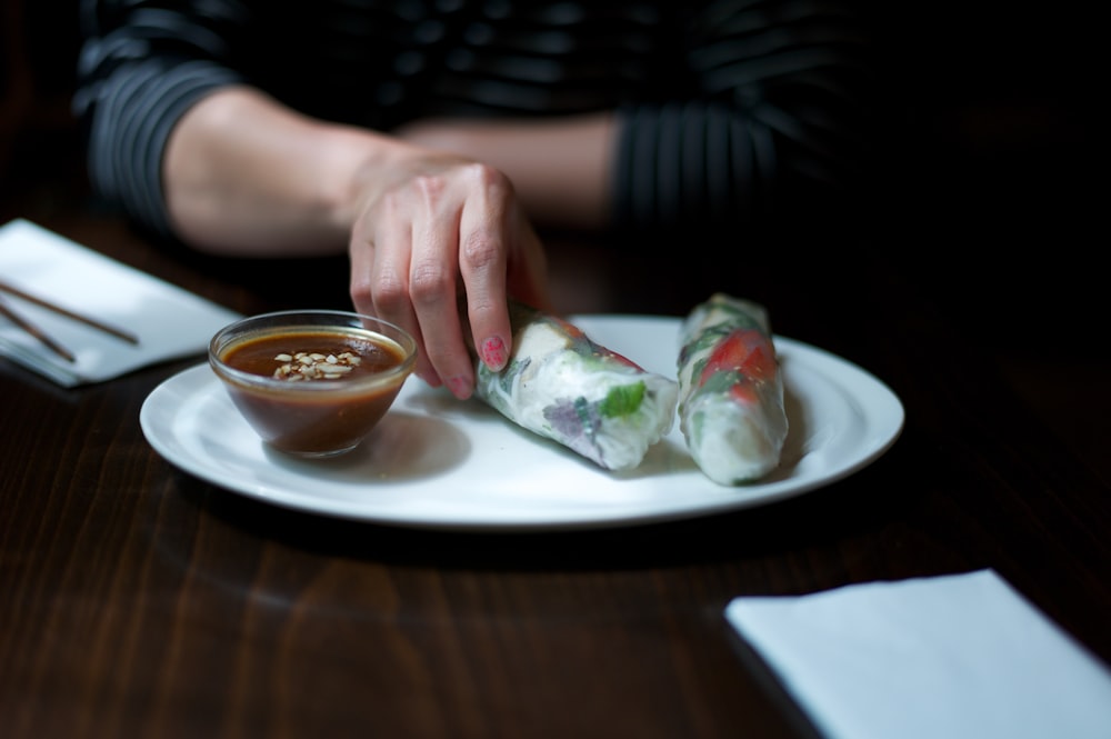 person holding white ceramic plate with food