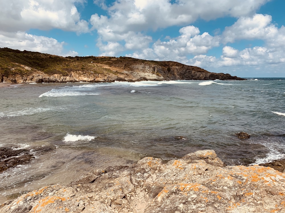 ocean waves crashing on rocky shore during daytime