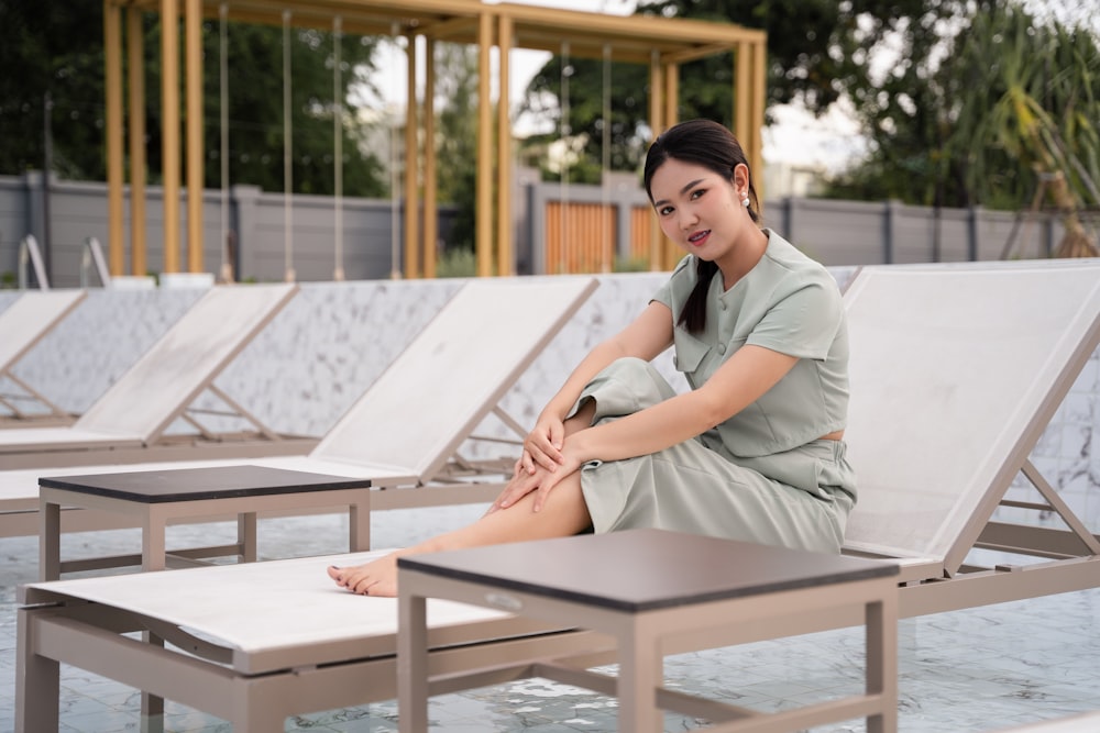 woman in gray dress shirt sitting on brown wooden picnic table during daytime