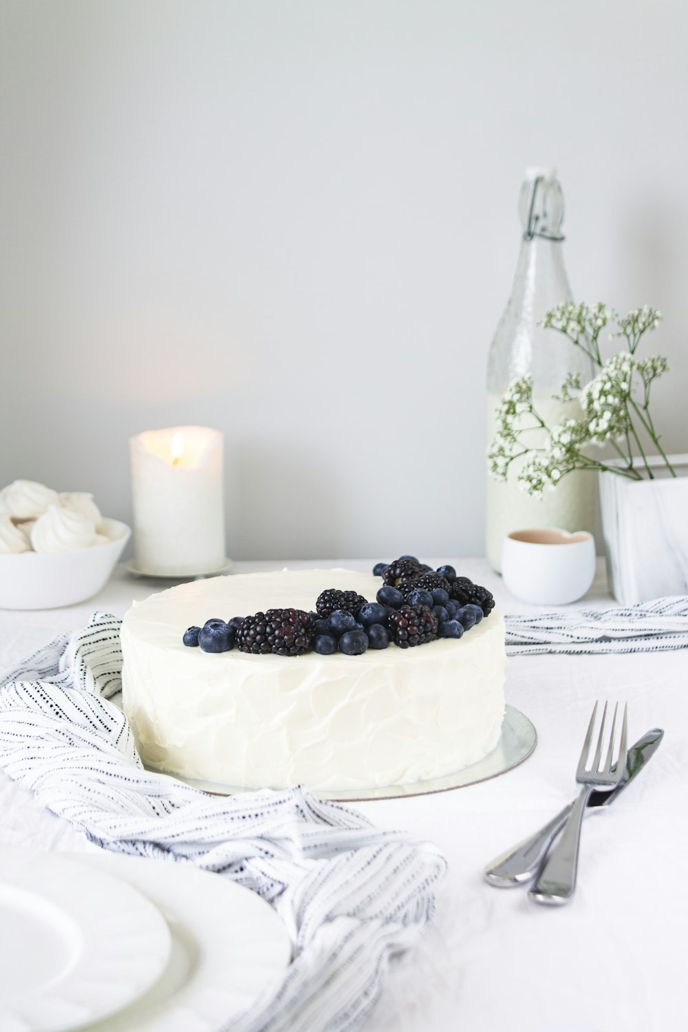 black berries on white ceramic plate beside stainless steel fork and knife