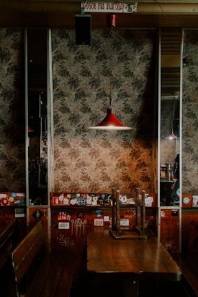 A rustic wooden table set with colorful dirty sodas and euro board games under warm, steampunk-style lighting.