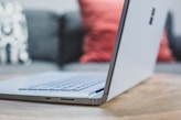 black and silver laptop computer on brown wooden table