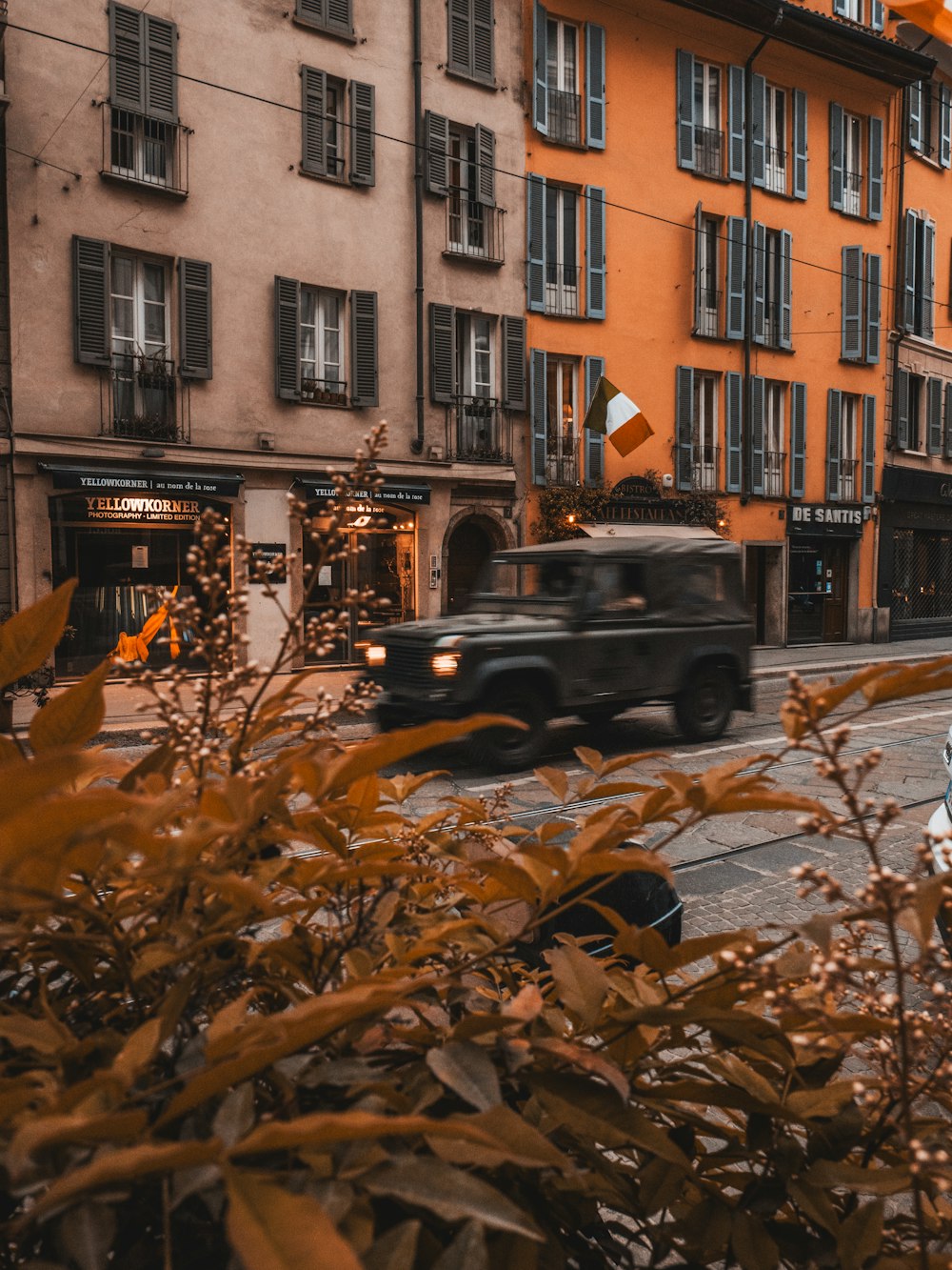 black car parked beside brown concrete building during daytime