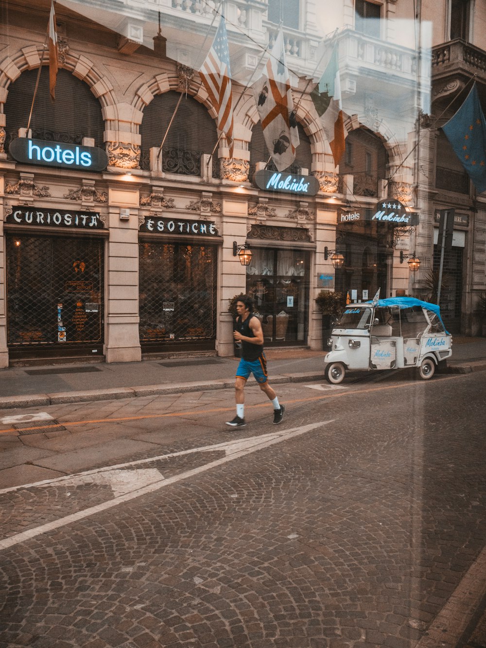 man in black jacket and blue denim jeans riding on bicycle on road near brown concrete