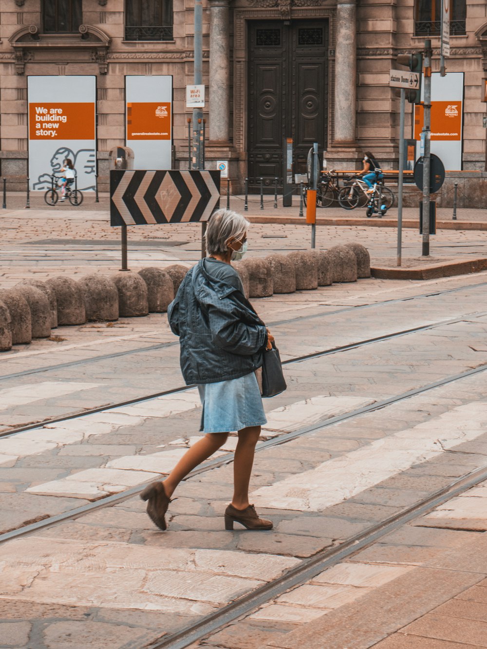woman in blue denim jacket standing on sidewalk during daytime