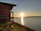 Sunset view over a peaceful lakeside cabin with natural beige and green surroundings