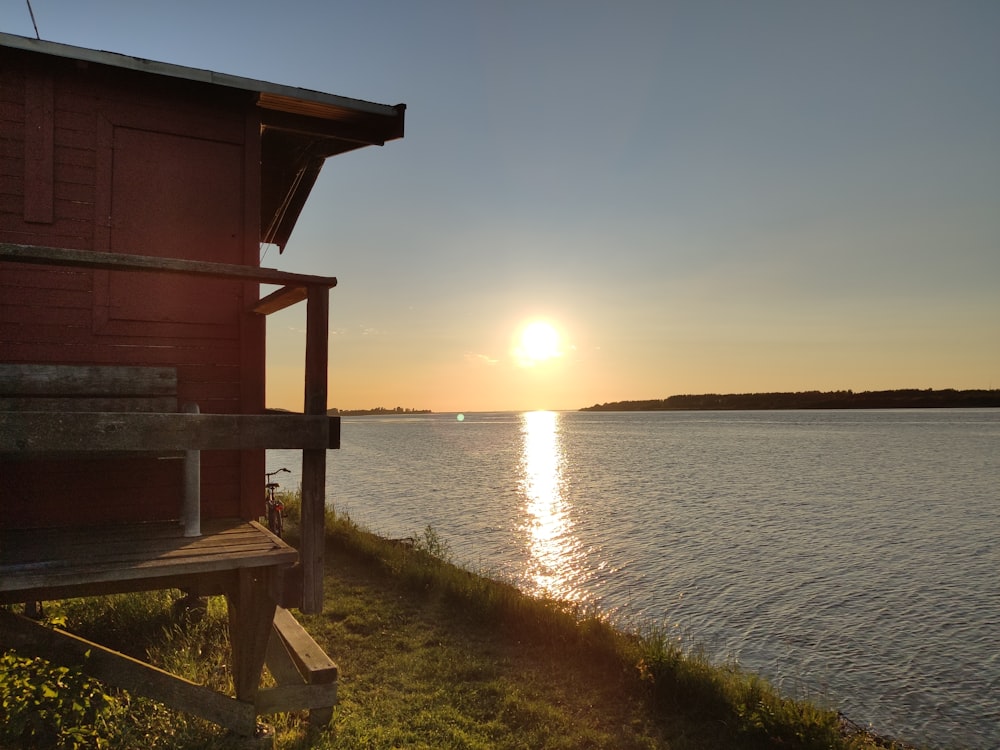 brown wooden dock on body of water during sunset