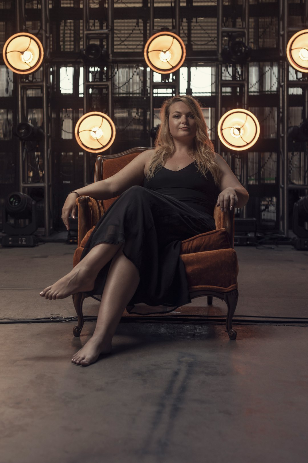 woman in black dress sitting on brown wooden armchair