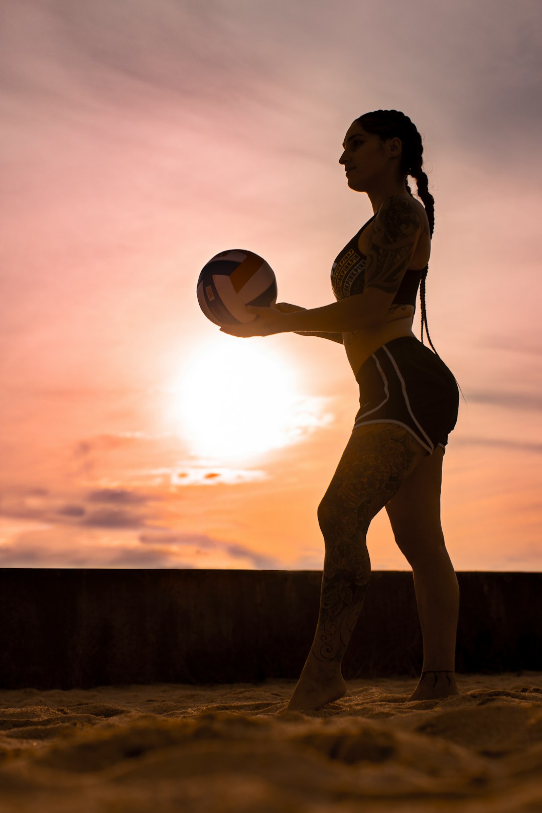 woman in white bikini holding yellow ball during sunset