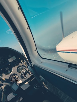 A student pilot reviewing flight charts with an instructor beside a small training airplane.