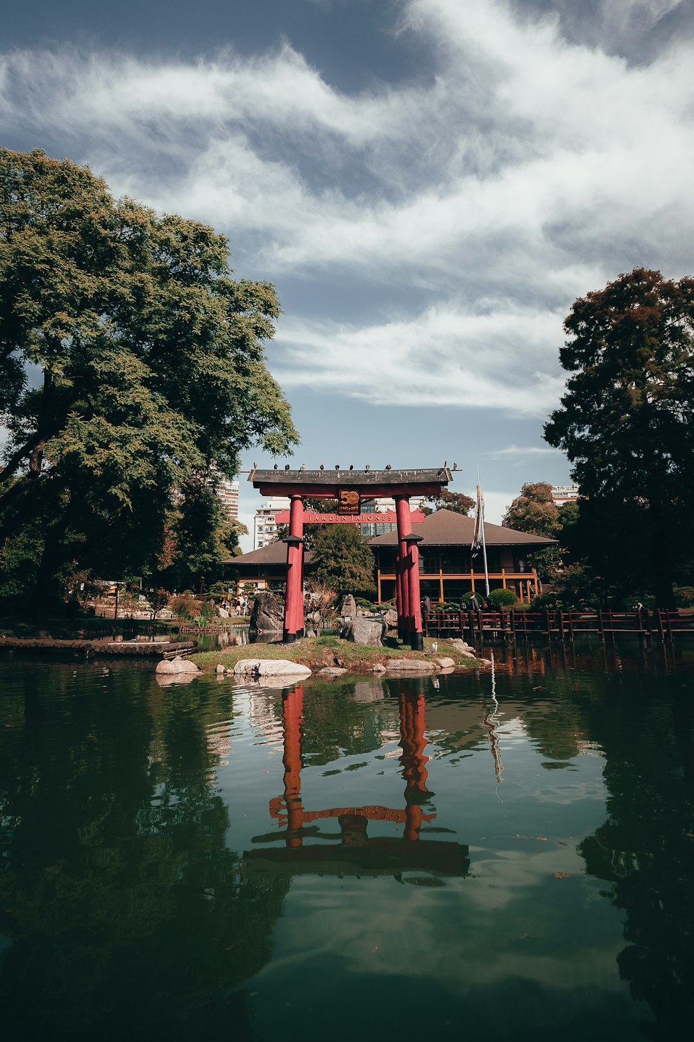 red and white concrete building near green trees and river during daytime