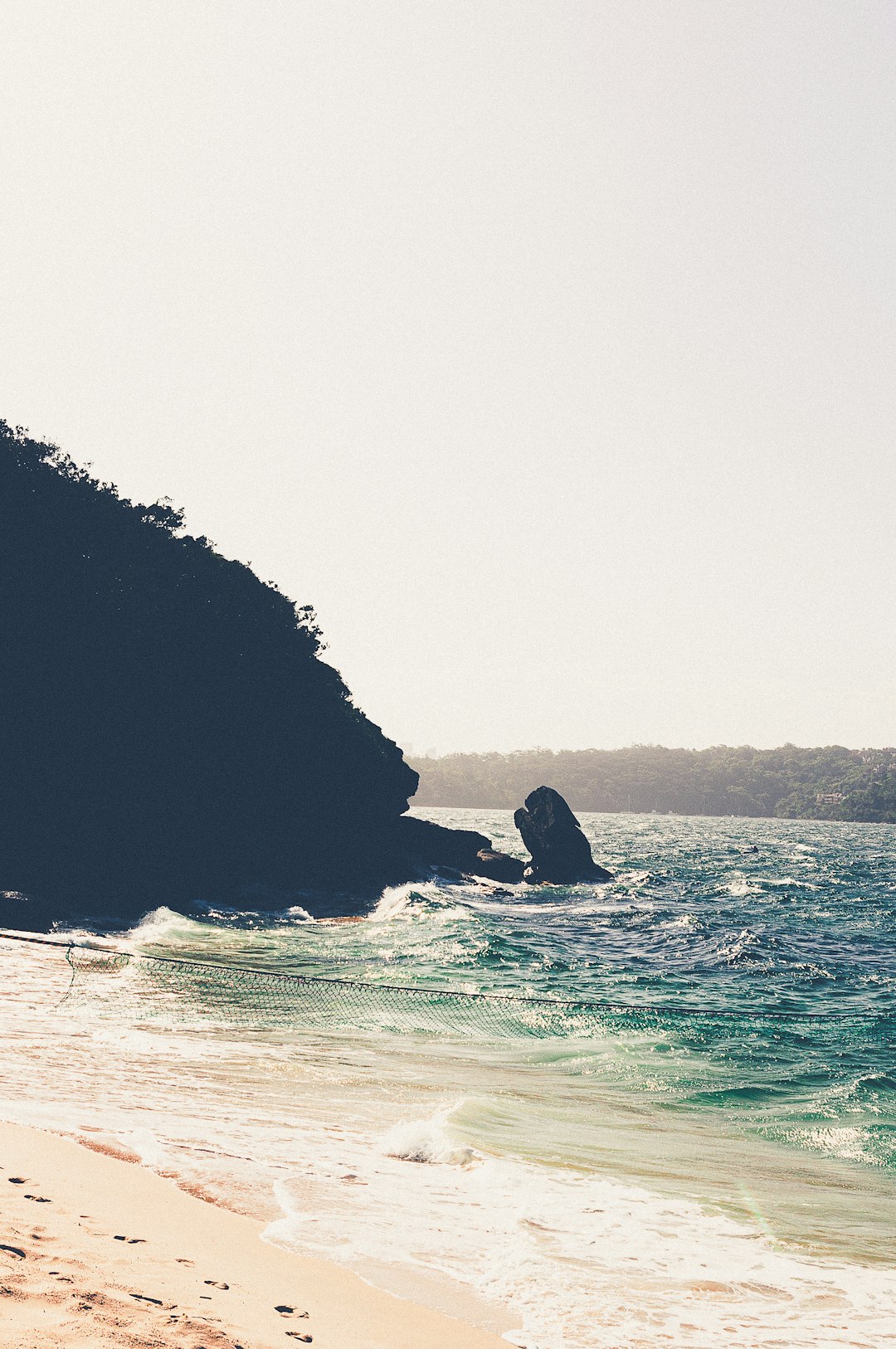 black rock formation on sea during daytime