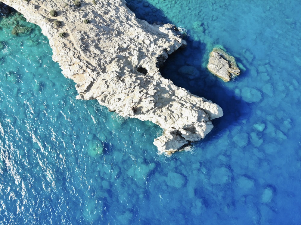 aerial view of gray and black rock formation on blue sea during daytime