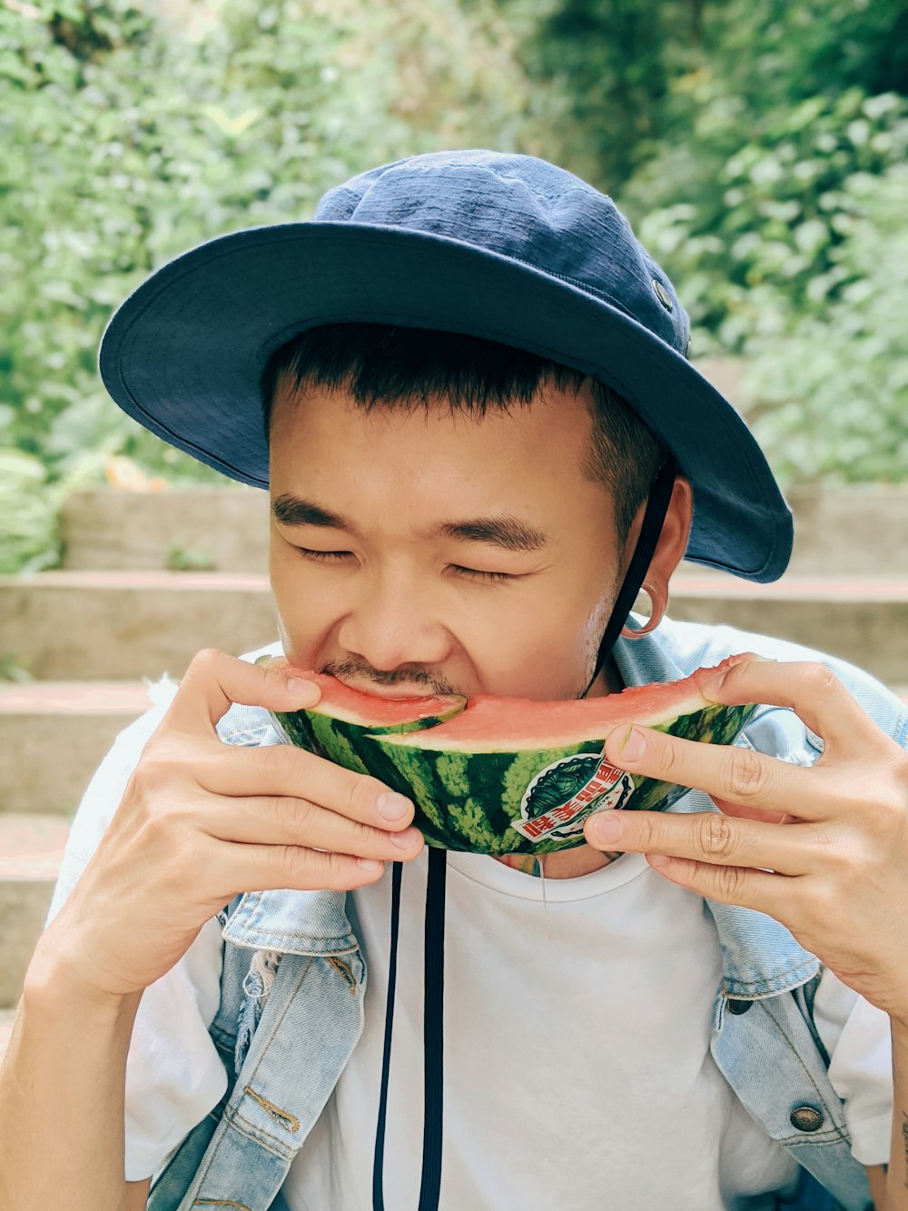 boy in white shirt eating watermelon