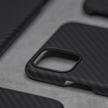 Close-up of a hand holding a sleek, modern phone case with a minimalist design.