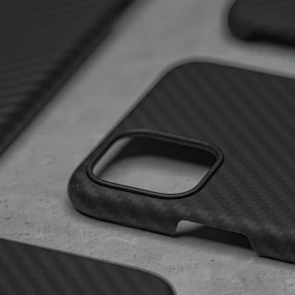 Minimalist styled iPhone with vxora titanium case resting on a dark textured surface.