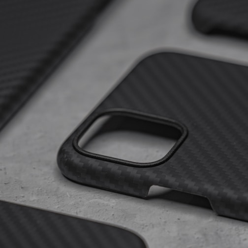 A sleek minimalist phone case in matte black on a wooden table.