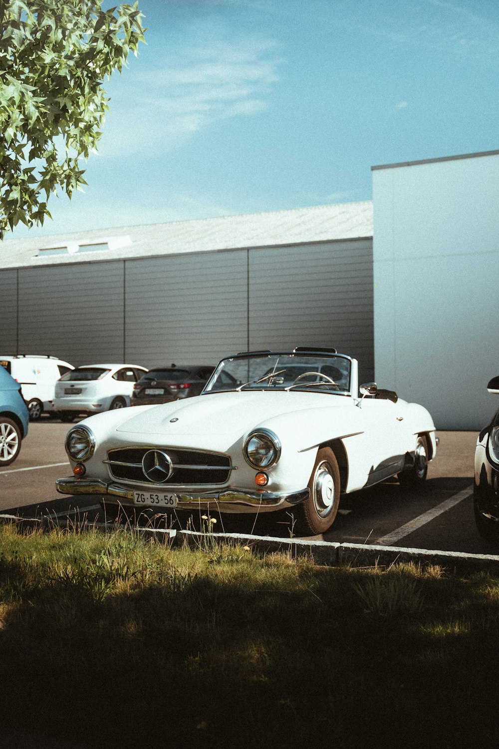 white classic car parked near building