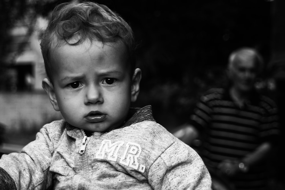 Foto en escala de grises de un niño con camisa abotonada