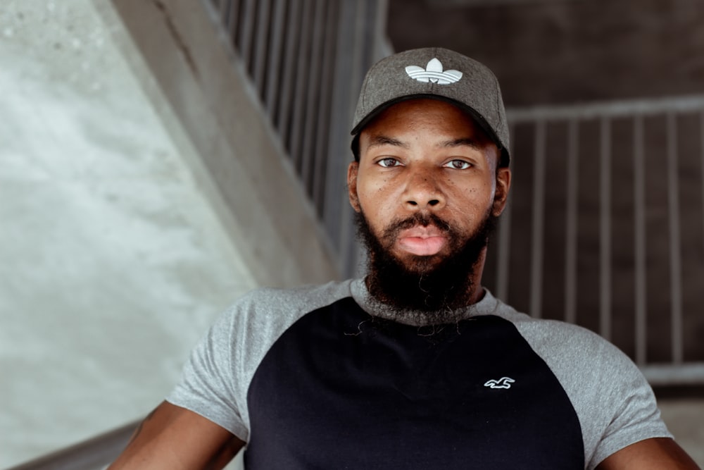 man in black and white crew neck t-shirt wearing black and white baseball cap