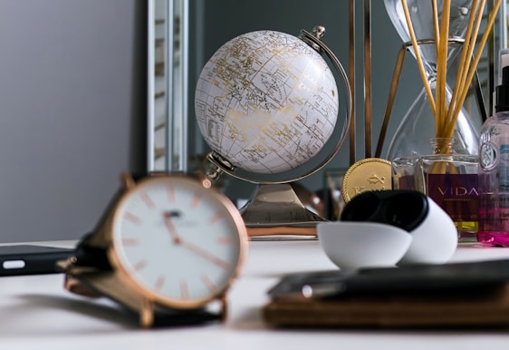 A warm, inviting workspace with elegant fragrance bottles and creative notes scattered on a wooden desk.