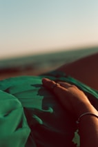 A traveler resting peacefully on a Bali beach with the wellness bag beside them.