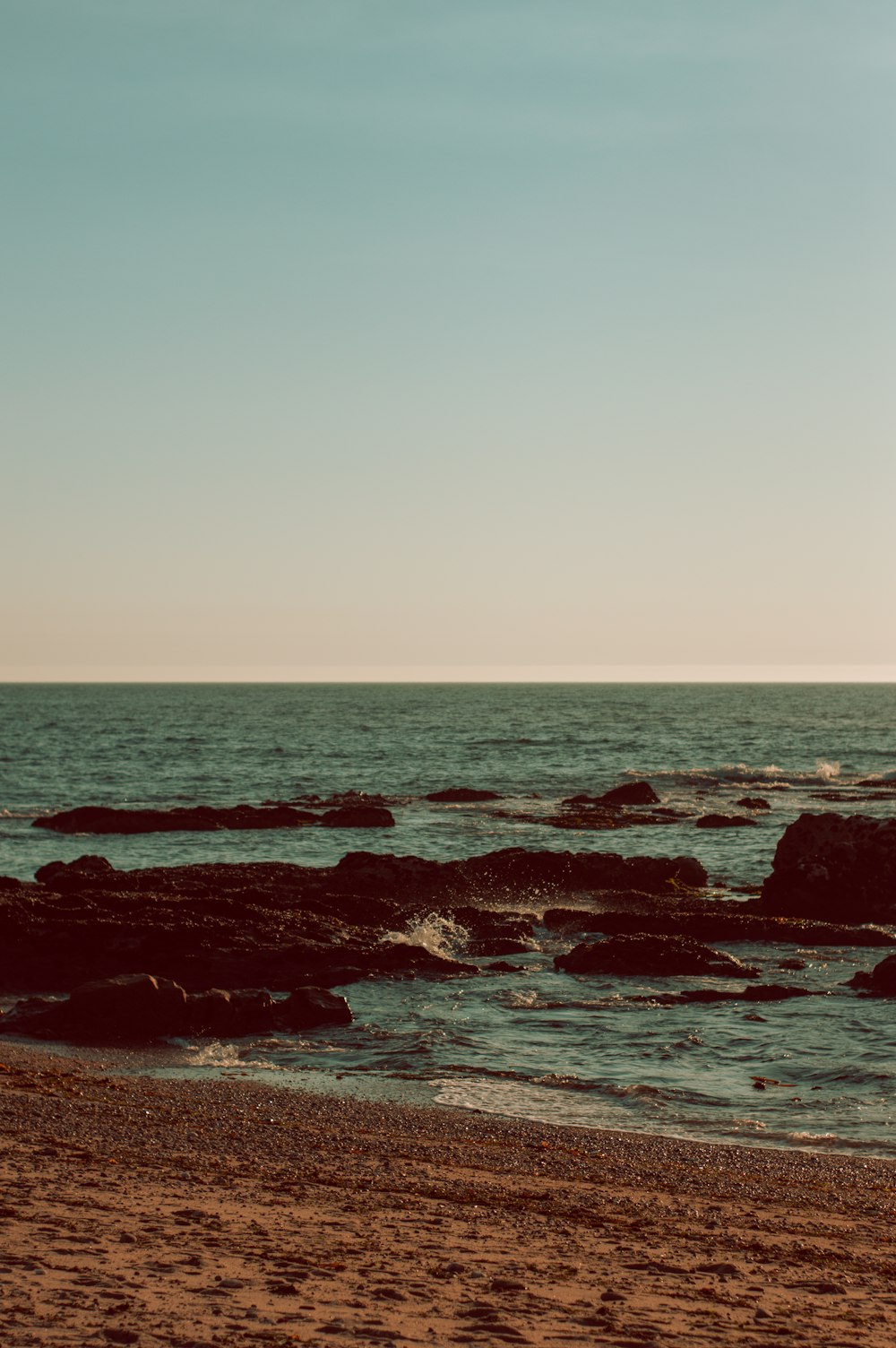 brown rocks on sea shore during daytime