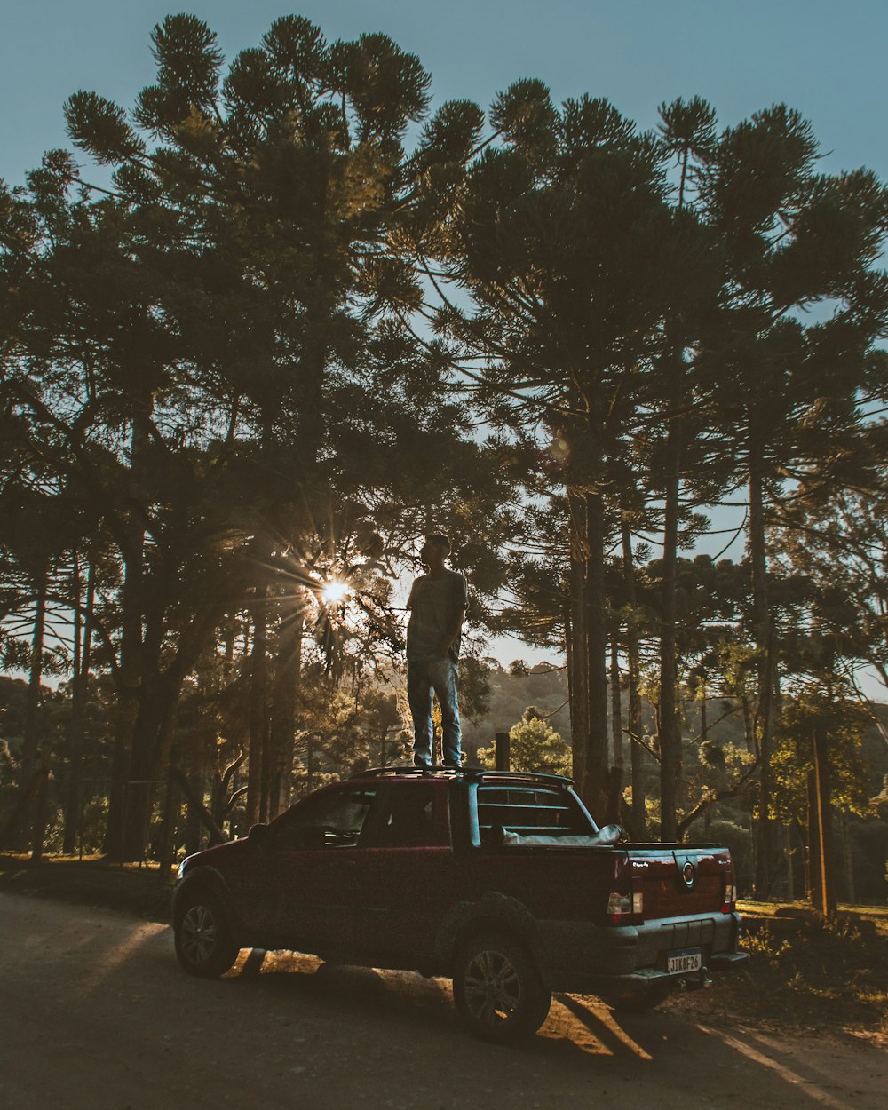 man standing on black suv on road during daytime