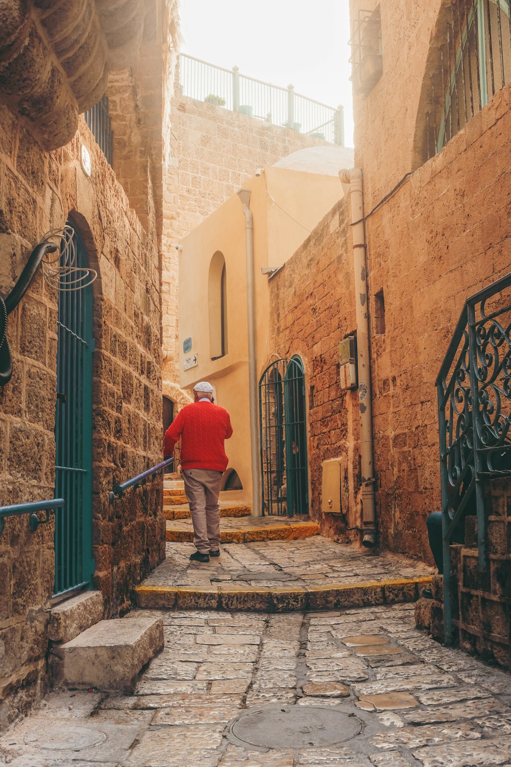 man in blue jacket walking on sidewalk during daytime