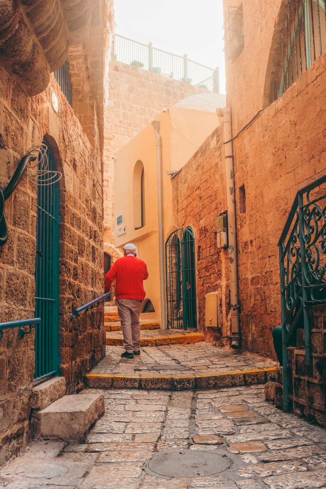 man in blue jacket walking on sidewalk during daytime