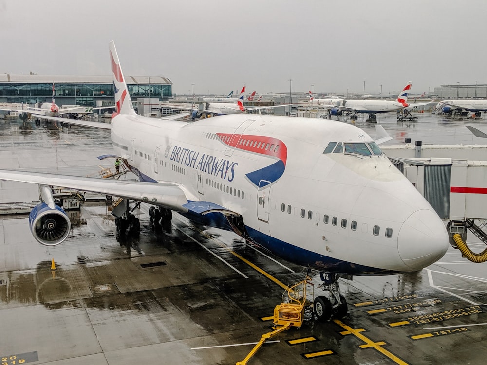 white and blue airplane on airport during daytime