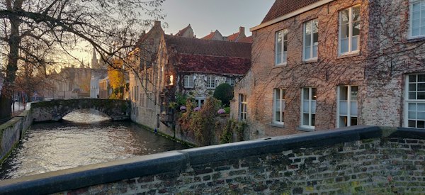 Brown brick building near river — Bruges, Belgium